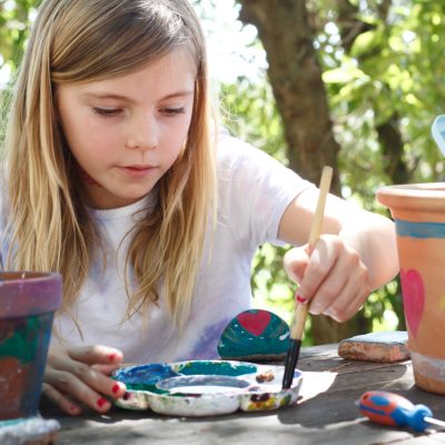 Girl painting plant pots arts and crafts